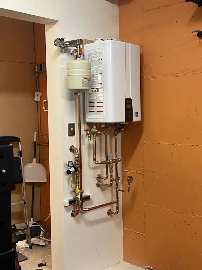 Plumbing technician inspecting water heater connections in Portsmouth